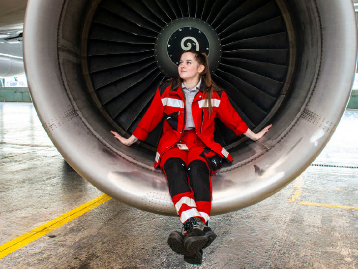 Junge Flugzeugmechanikerin sitzt im Fan des Flugzeugtriebwerks © Scheichel 